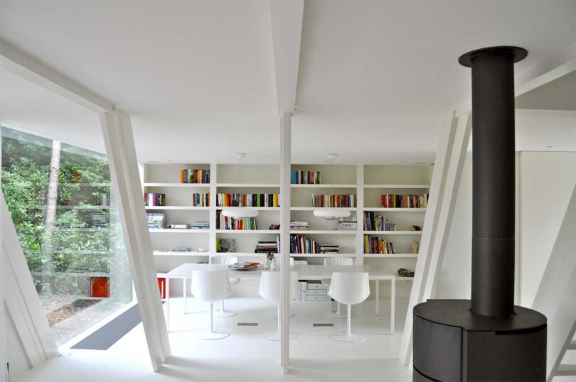 interior shot of modern a-frame house with all white interior in home office with books