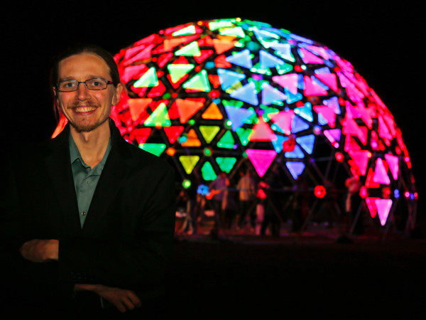 Yona Appletree poses in front of the illuminated Radiance Dome