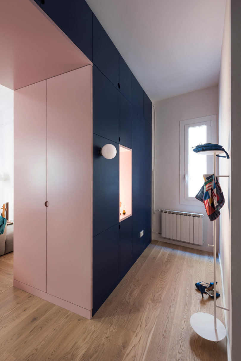 built-in structure of storage cabinets in navy and pink