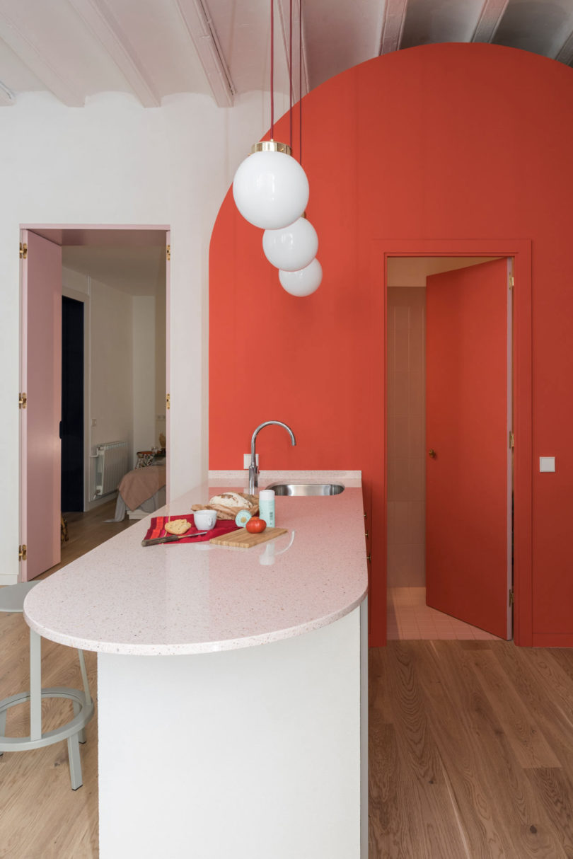 vista interior lateral da cozinha moderna com quarto arqueado laranja dentro de um quarto