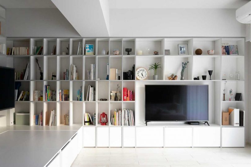 interior shot of modern apartment with wall of white bookcases