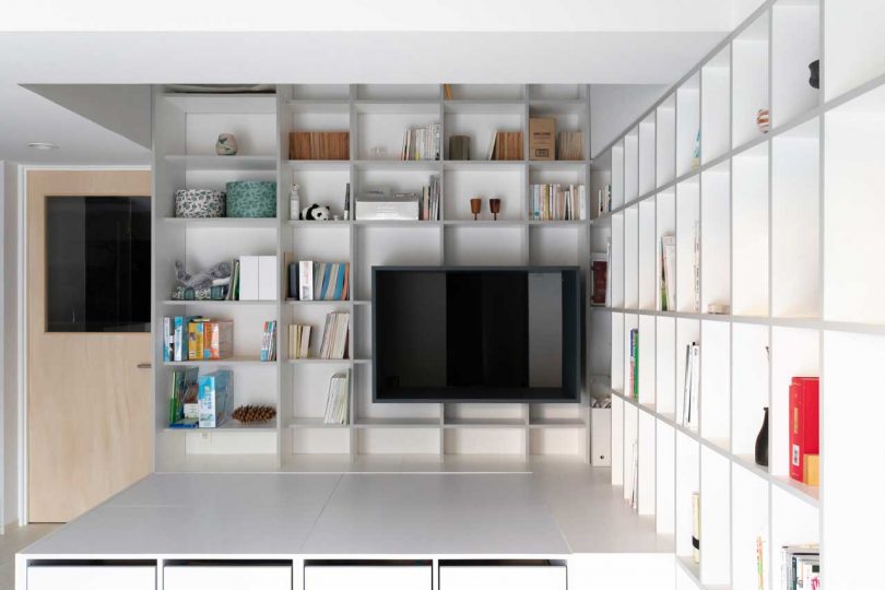 interior shot of modern apartment with floor to ceiling white bookcases