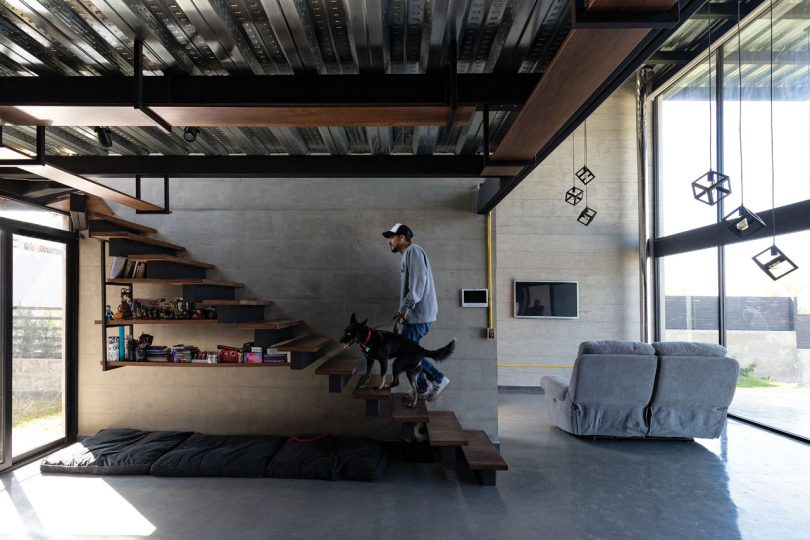 interior view of industrial modern house with open stairs and man climbing them
