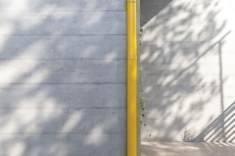 closeup exterior view of grey stone with yellow pipe