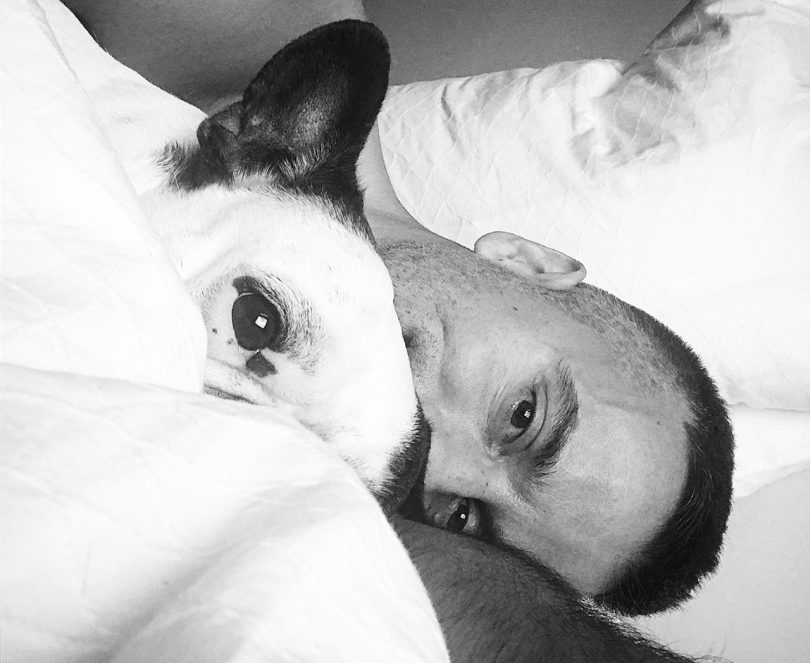 man and dog in bed