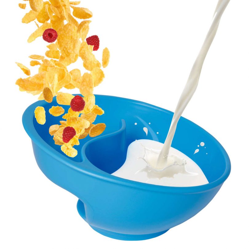 bowl with cereal and milk being poured into it