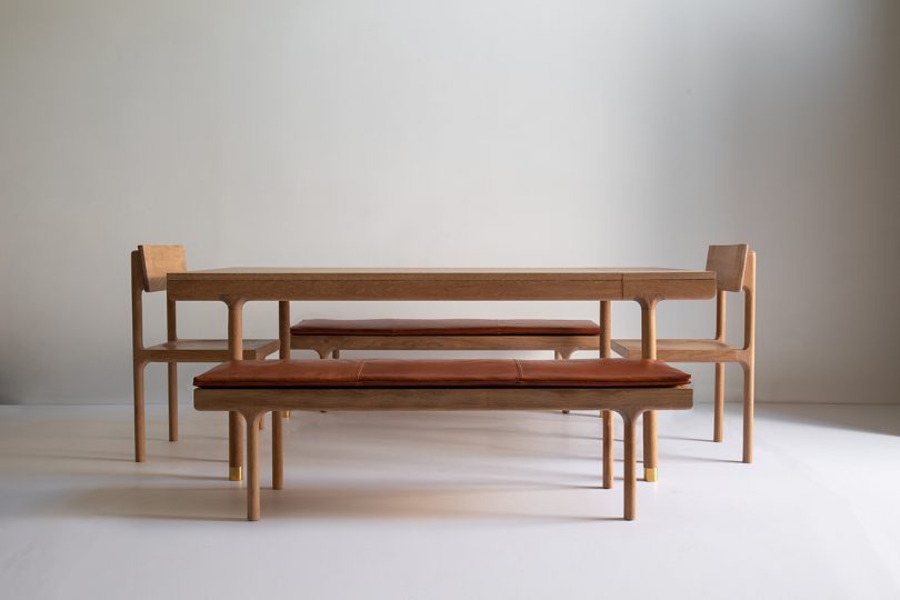 Oak dining table, dining chair, and leather topped bench in light space
