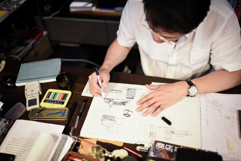 man drawing at desk