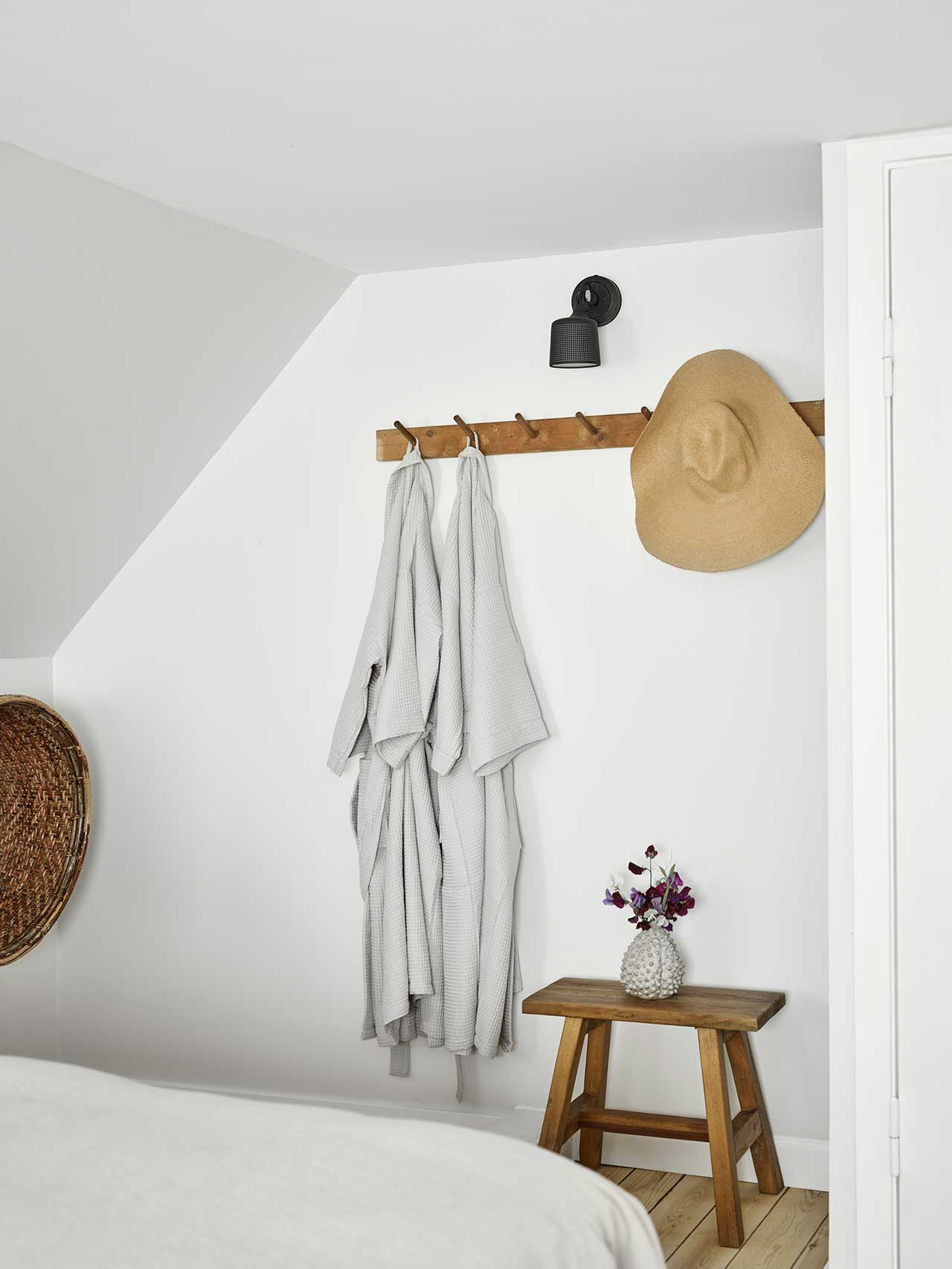 wall rack holding bathrobes and hat