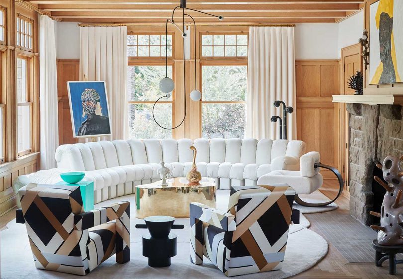 living room with curved sofa and bold print chairs