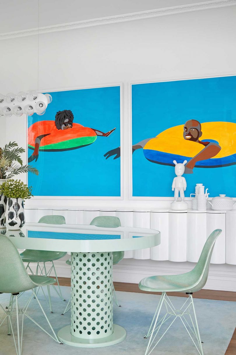 eating area with pale green furnishings and bold art