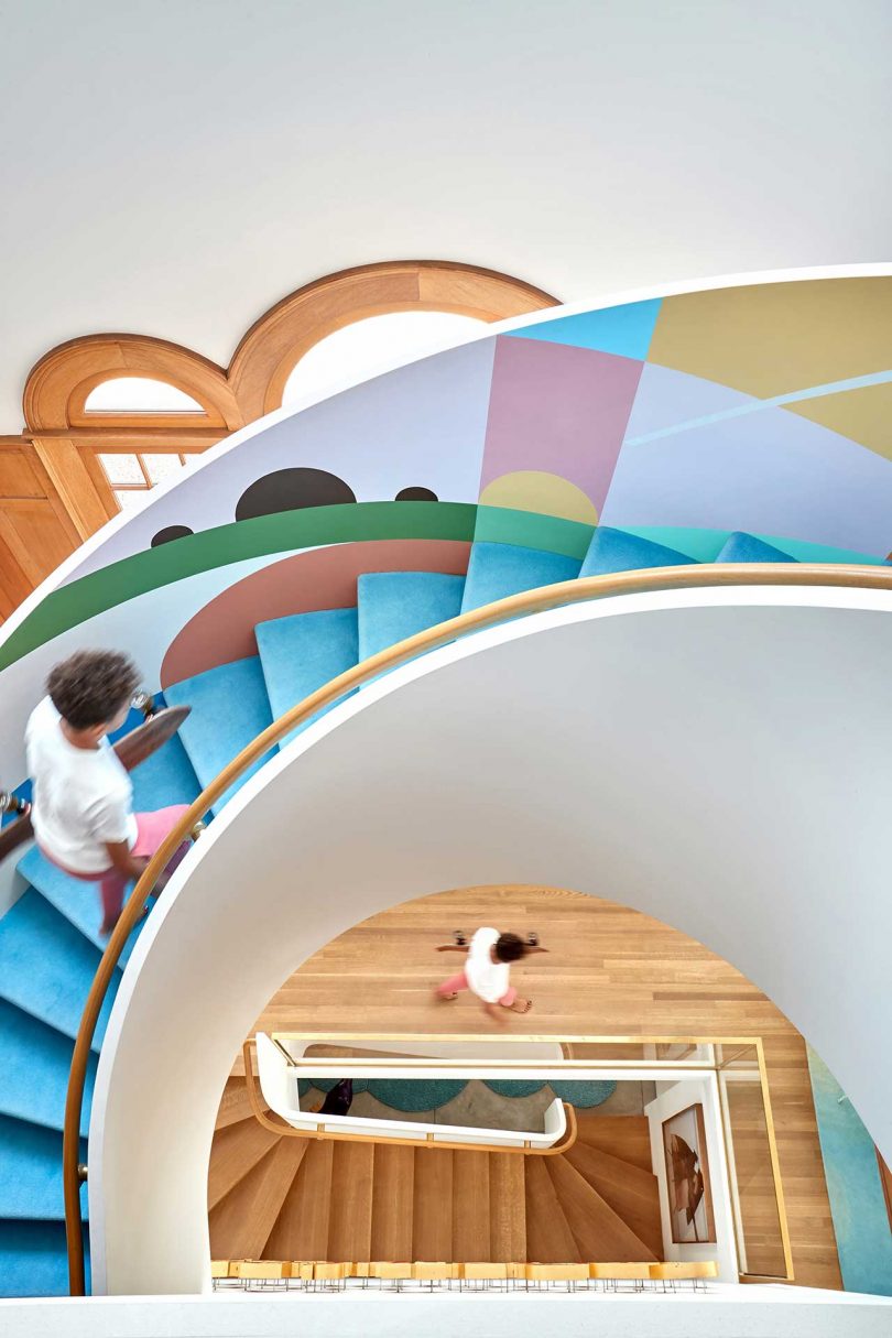 a curved staircase with bright blue and geometric graphics