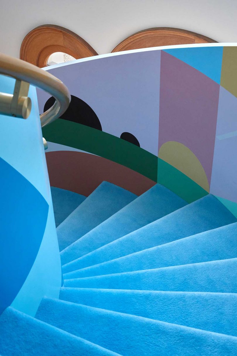 a curved staircase with bright blue and geometric graphics