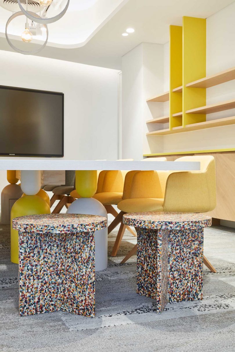 modern white office with yellow shelves and chairs