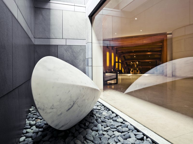 artful sculpture sitting on rocks behind glass