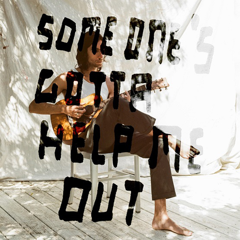 light-skinng man sitting and playing guitar with overlay text reading someone gotta help me out