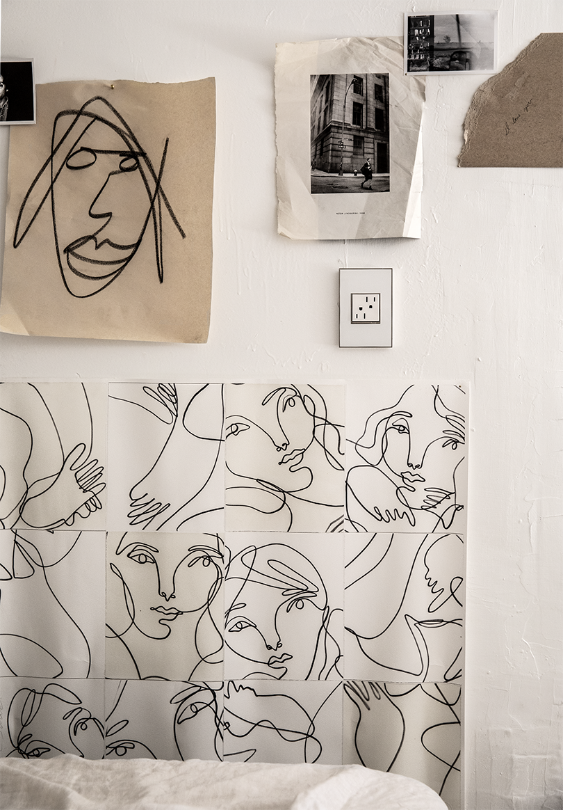 white wall with drawing hanging on it