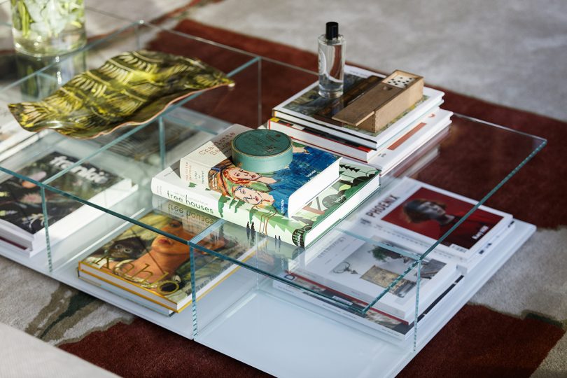 clear coffee table stacked with books