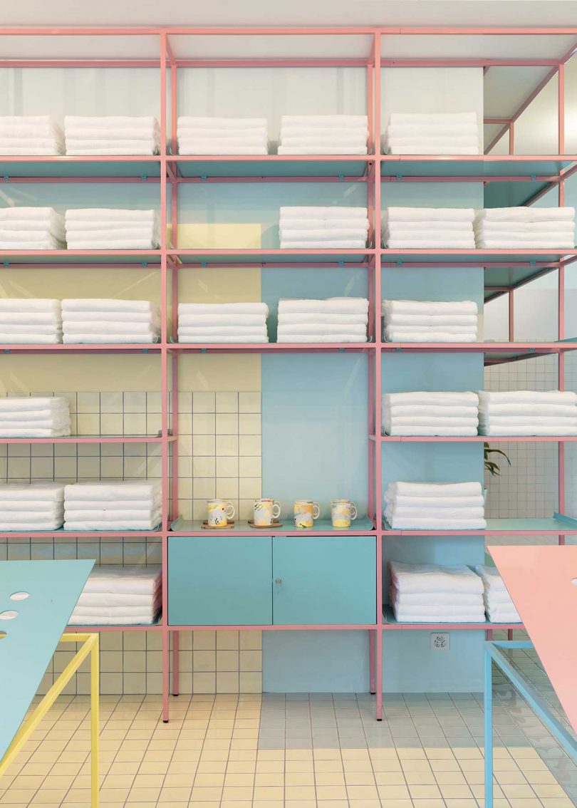 shelving in pastel tiled room with white towels