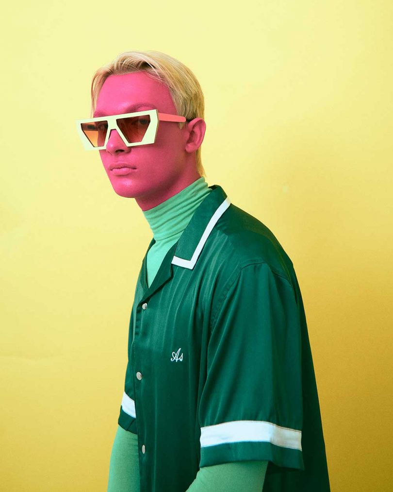 man with pink face and green shirts wearing sunglasses