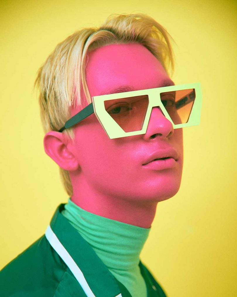 man with pink face and green shirts wearing sunglasses