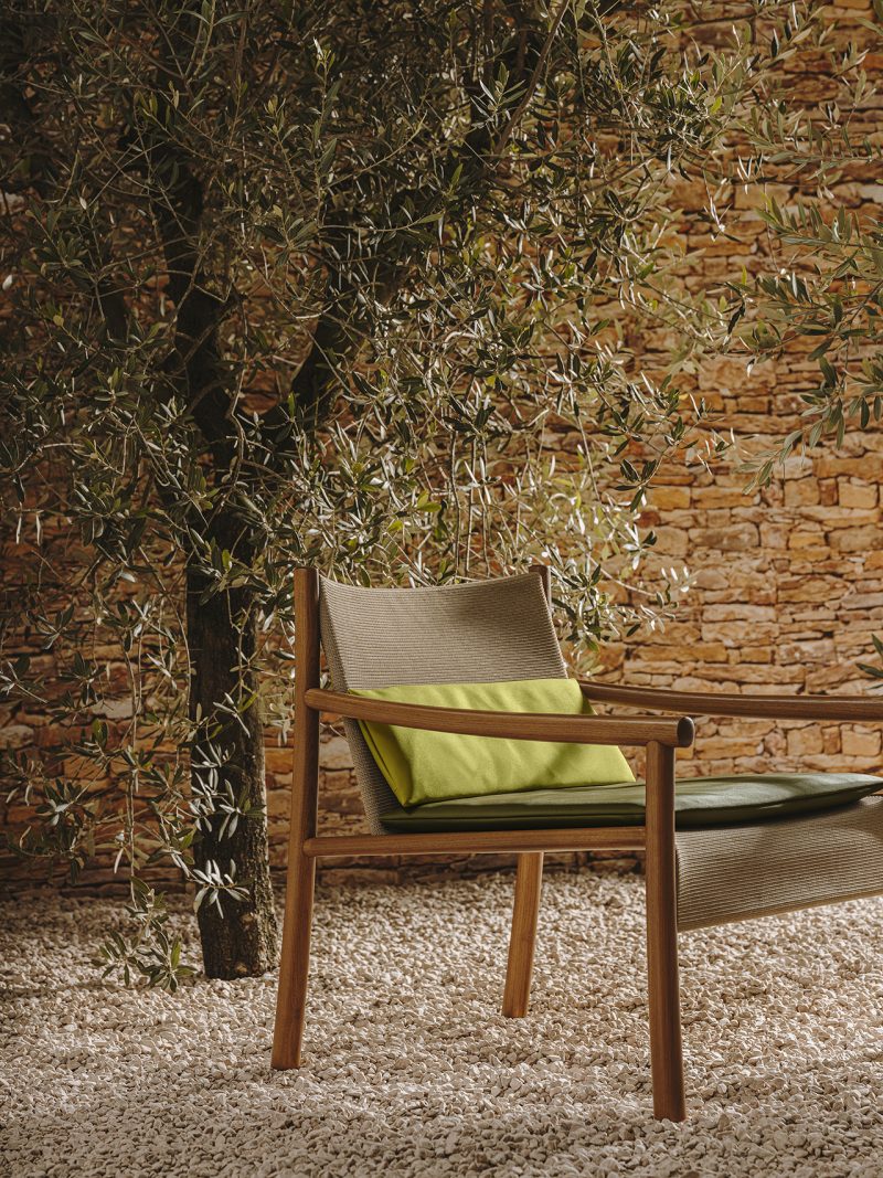 olive green armchair with greenery and gravel