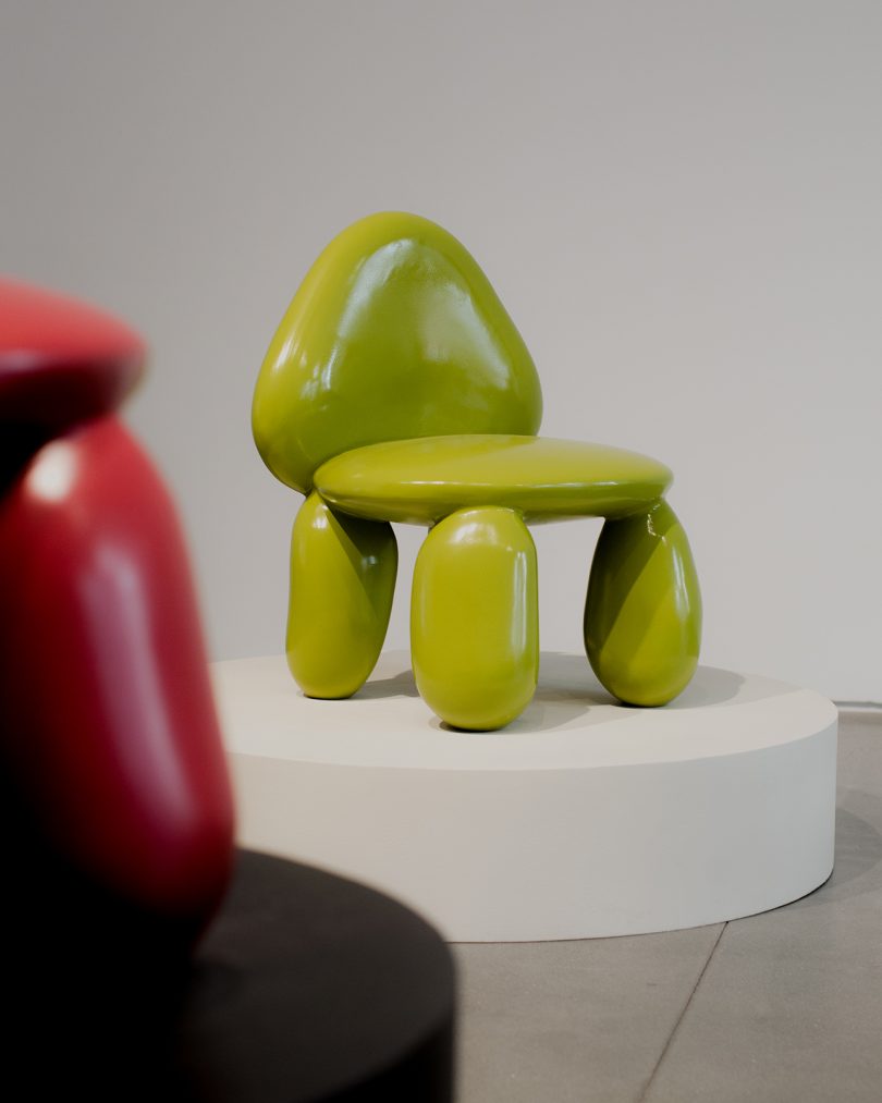 sculptural lime green chair on white pedestal