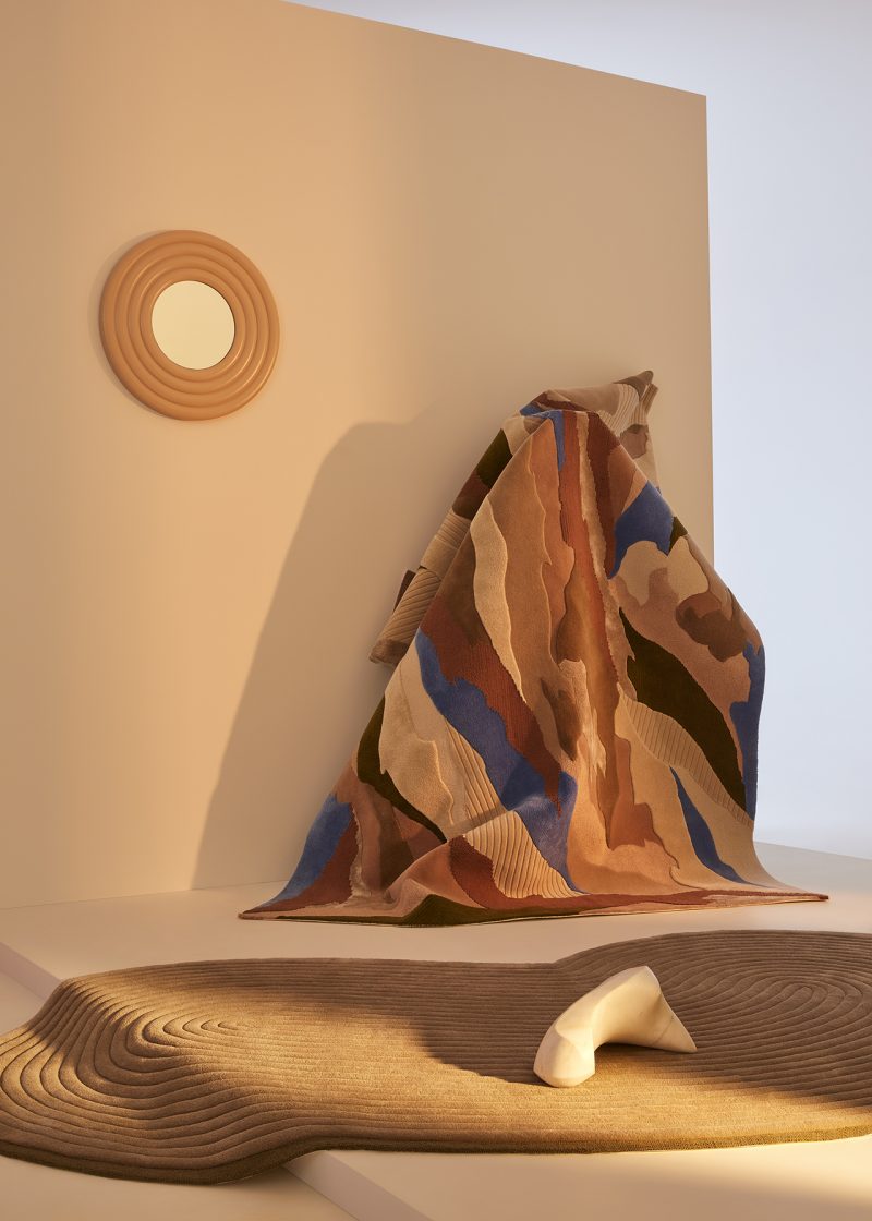 two styled rugs in an indoor space with mirror and soft lighting