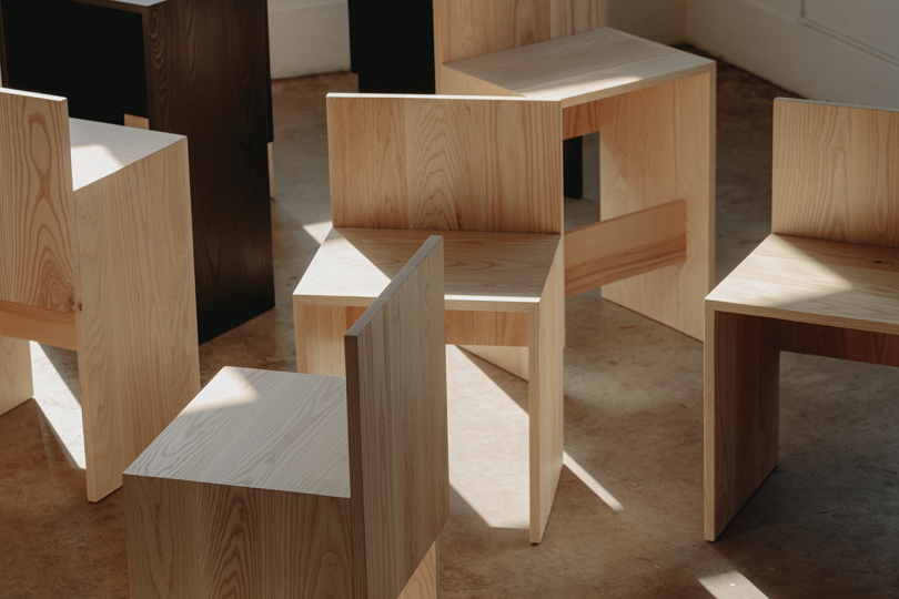 group of primitive wood chairs on concrete floor