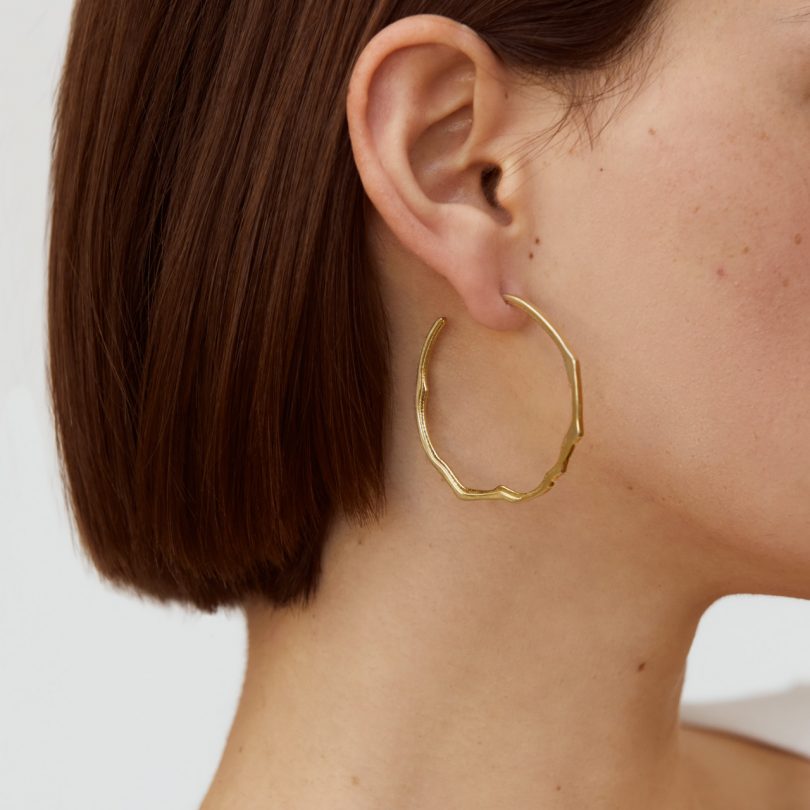 gold modern hoop earrings on model