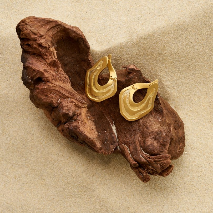 gold earrings on wood