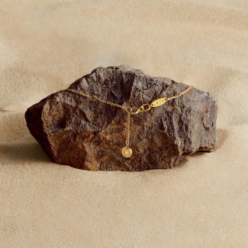 gold plated necklace on rock