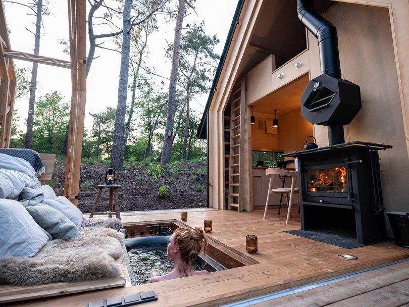 open roof cabin in the woods with girl in hot tub