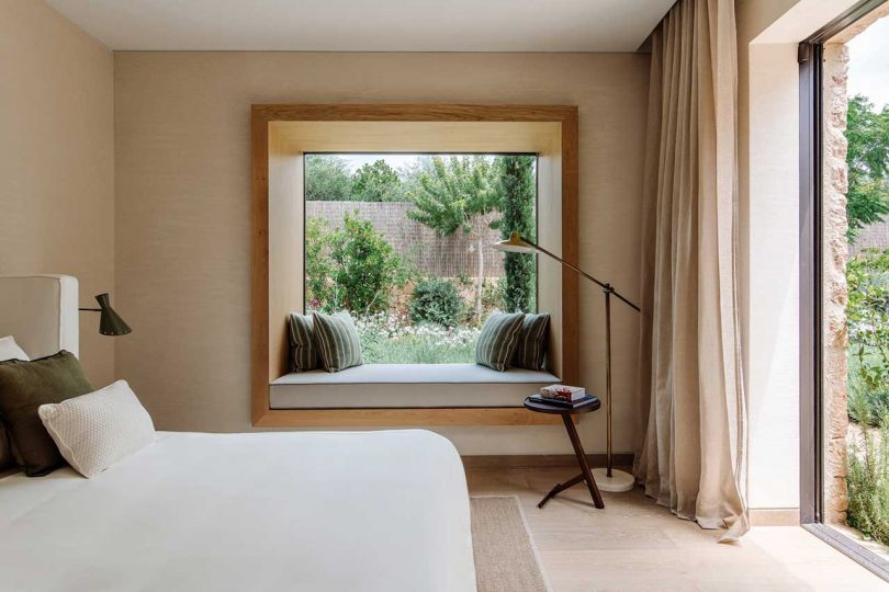 modern bedroom with white bedding and window with seat