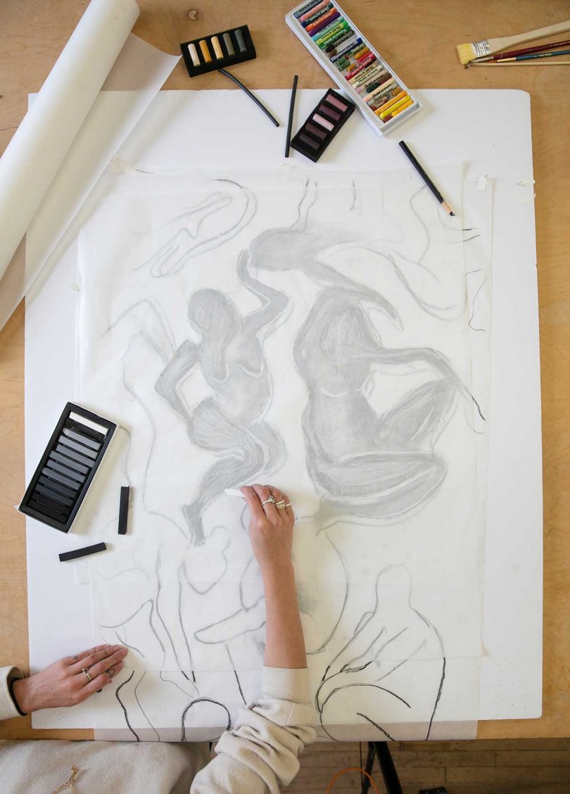 artist preparing layout of drawing over tracing paper