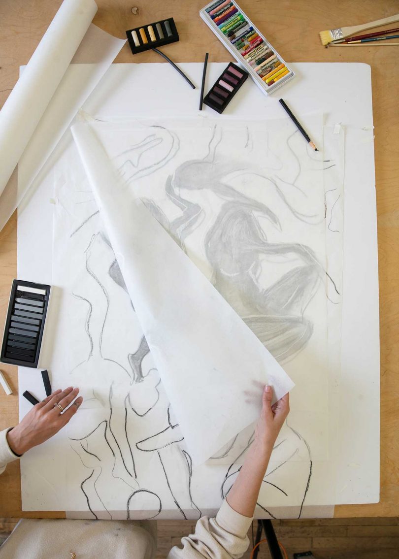 artist inspecting abstract drawing through trace paper