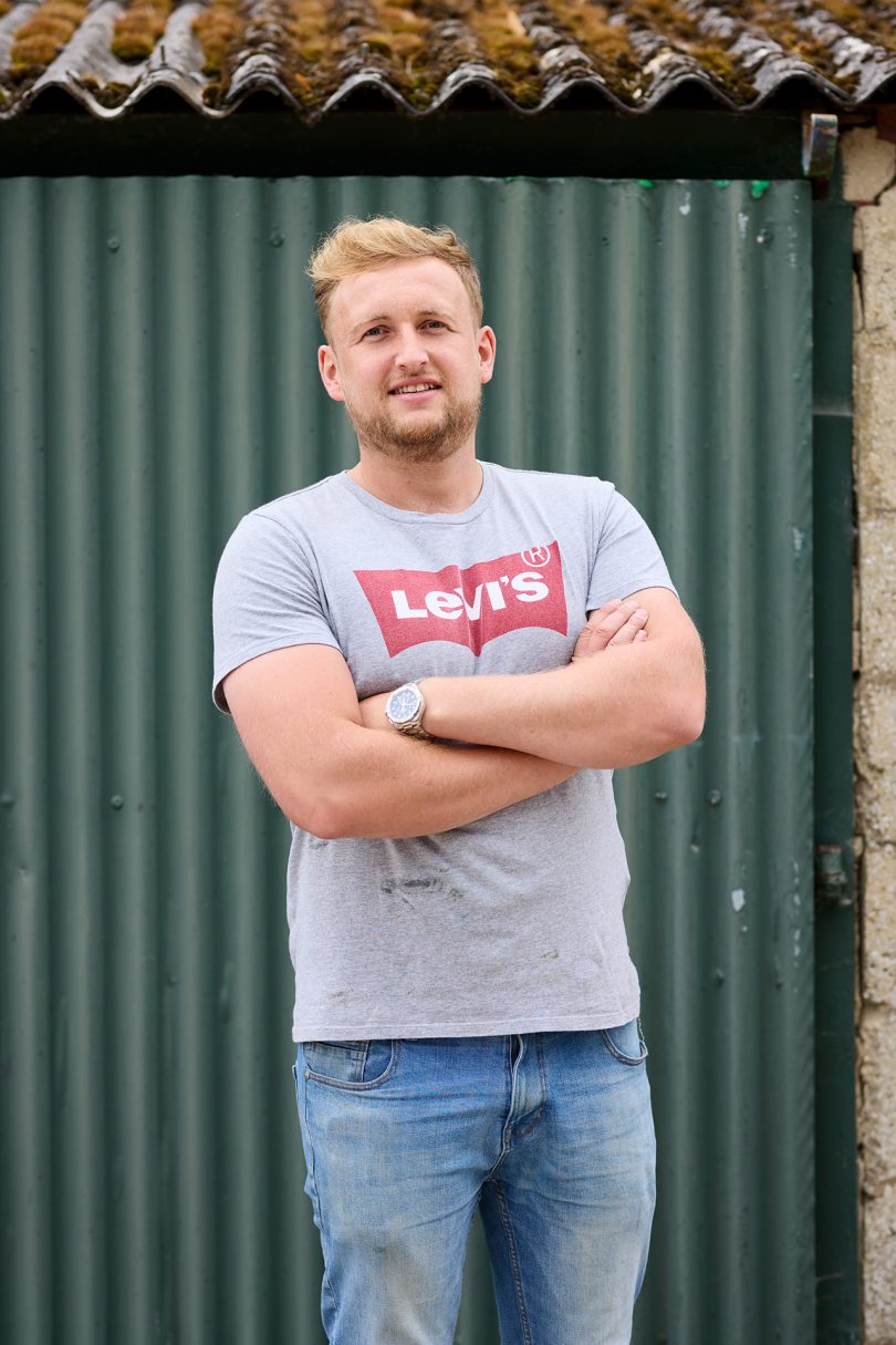 slight skinned man with light hair wearing a grey Levi's t-shirt and jeans