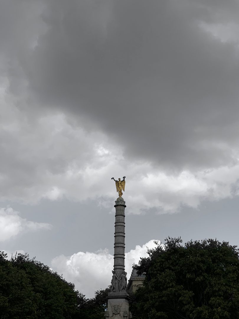 tall pillar statue with ominous clouds