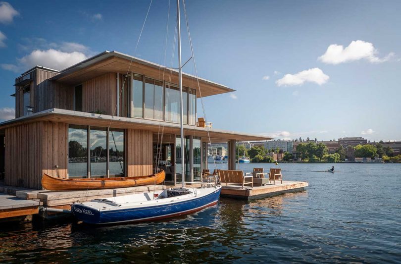 modern cabin floating in the water with docked sailboat