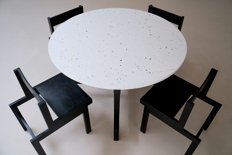 round white table surrounded by four dark dining chairs
