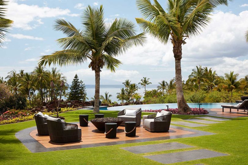  yard deck with surrounding palm trees and swimming pool in the background