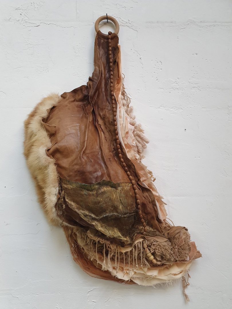 brown textile art hanging on white wall