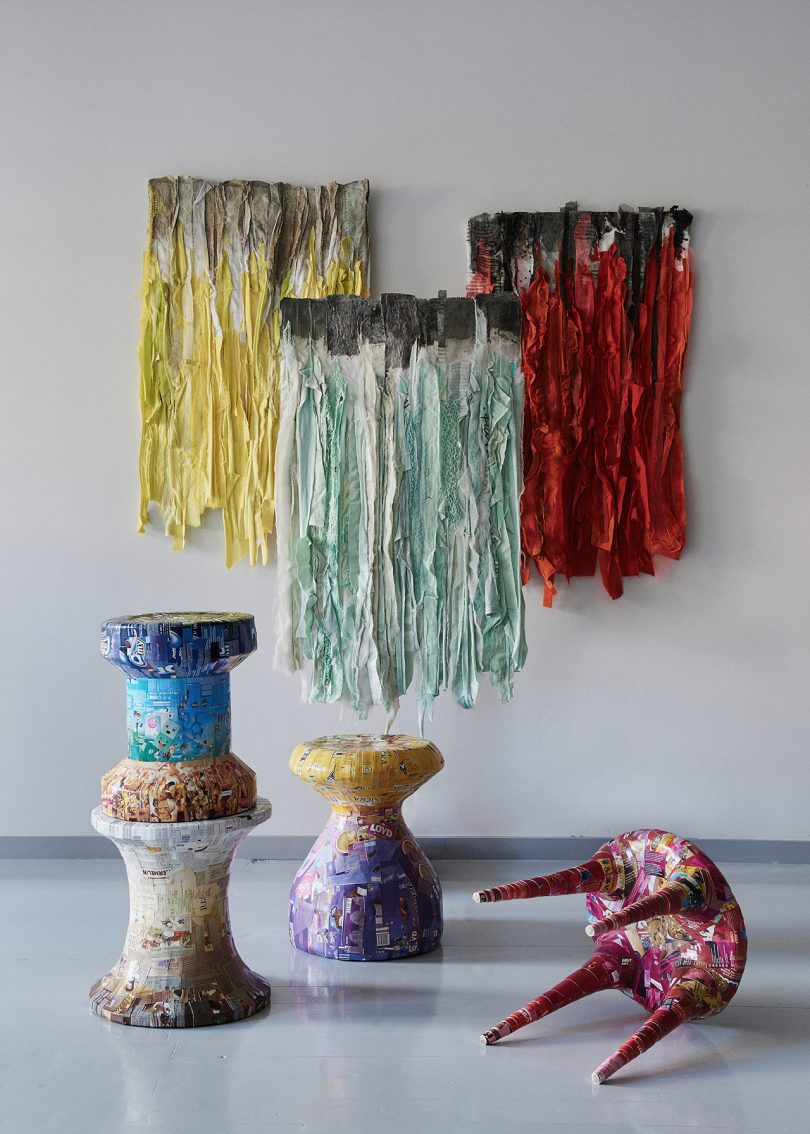 colorful textile art and functional objects displayed on wall and floor
