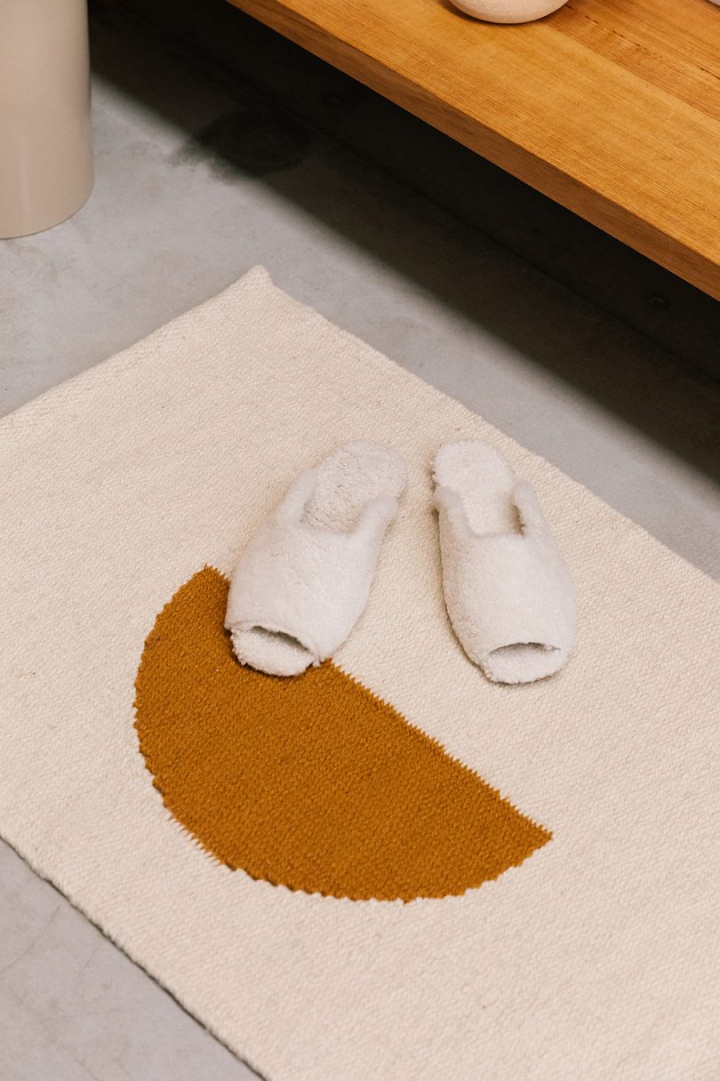 close up of woven rug and white slippers