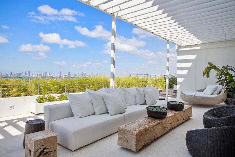 covered patio in penthouse with white sofa overlooking city