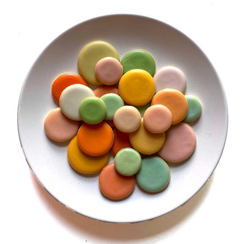 colorful round cookies with icing on white plate