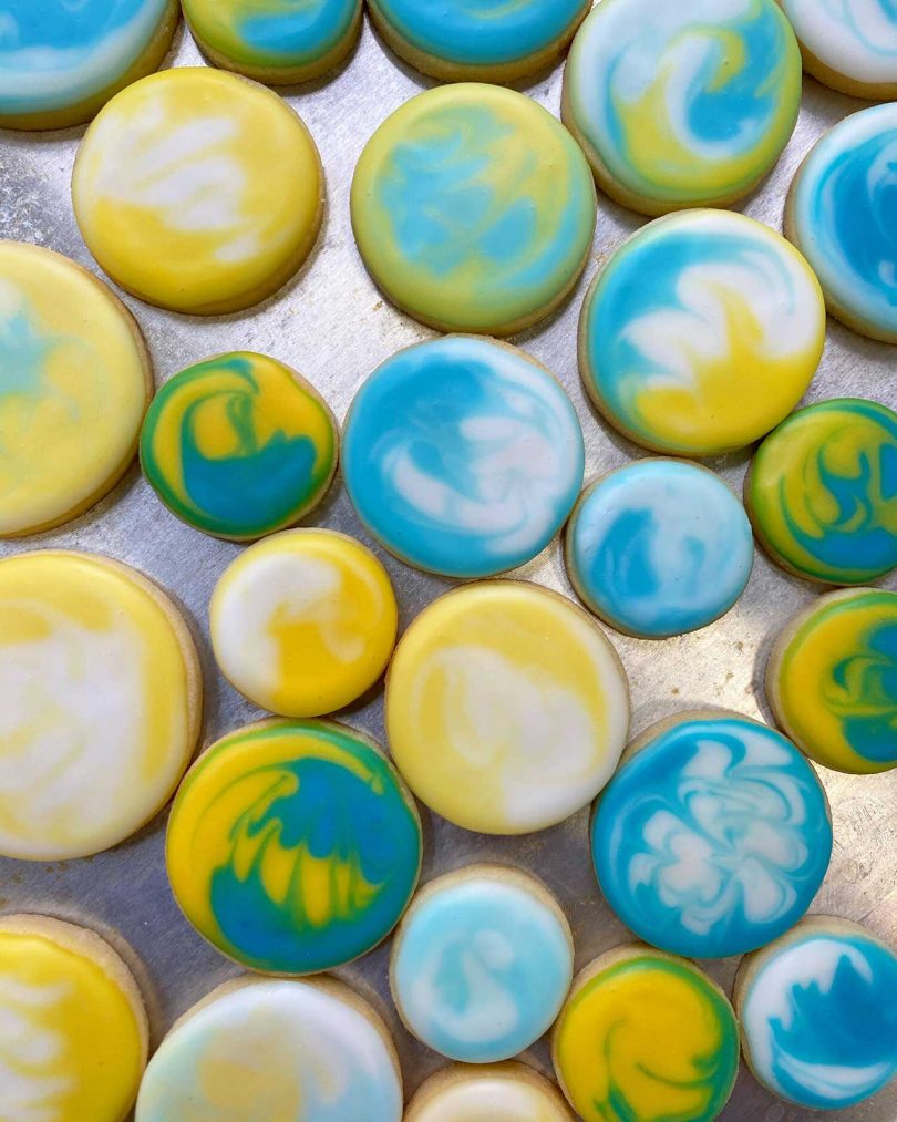 cookies with swirls of yellow, white and aqua icing