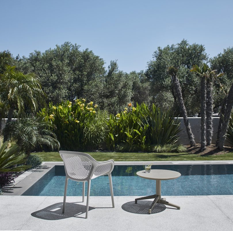 outdoor armchair and side table next to pool