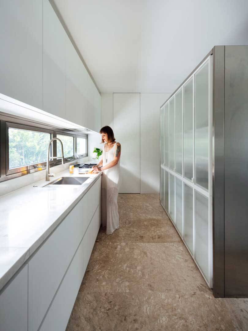 modern galley kitchen with white cabinets and windows as backsplash