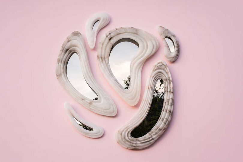 six abstract wall mirrors hanging on pink wall